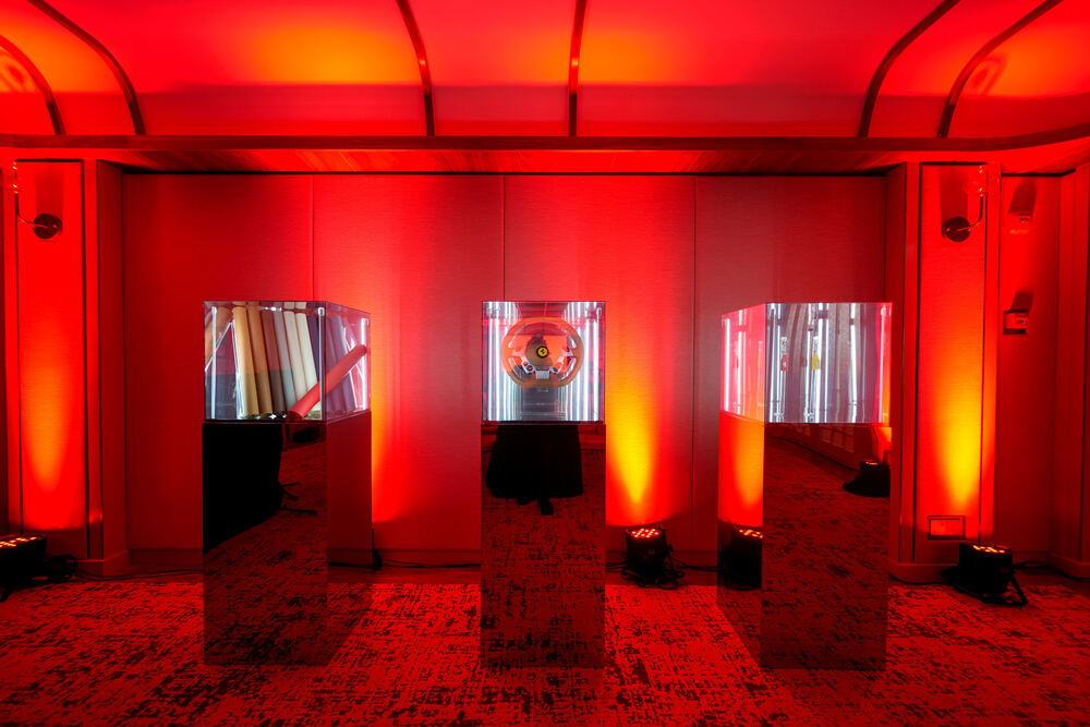 Brand exhibit with red uplighting and mirror plinths