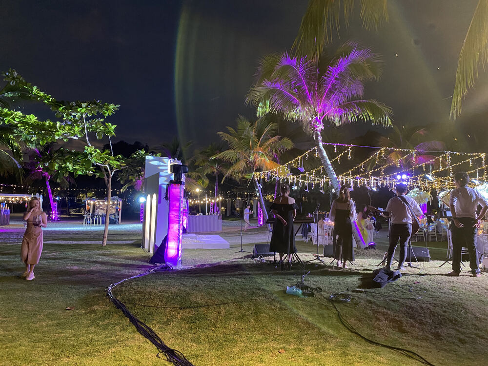 Outdoor beach stage with live band and fairy lights